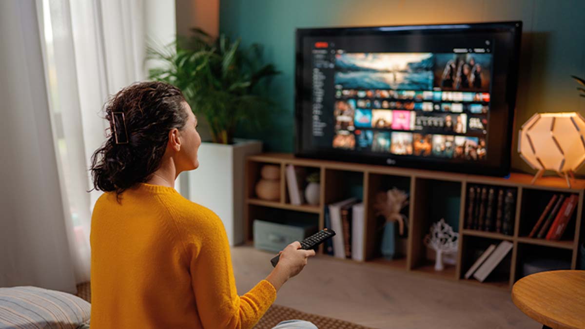 Mulher na sua sala a ver televisão